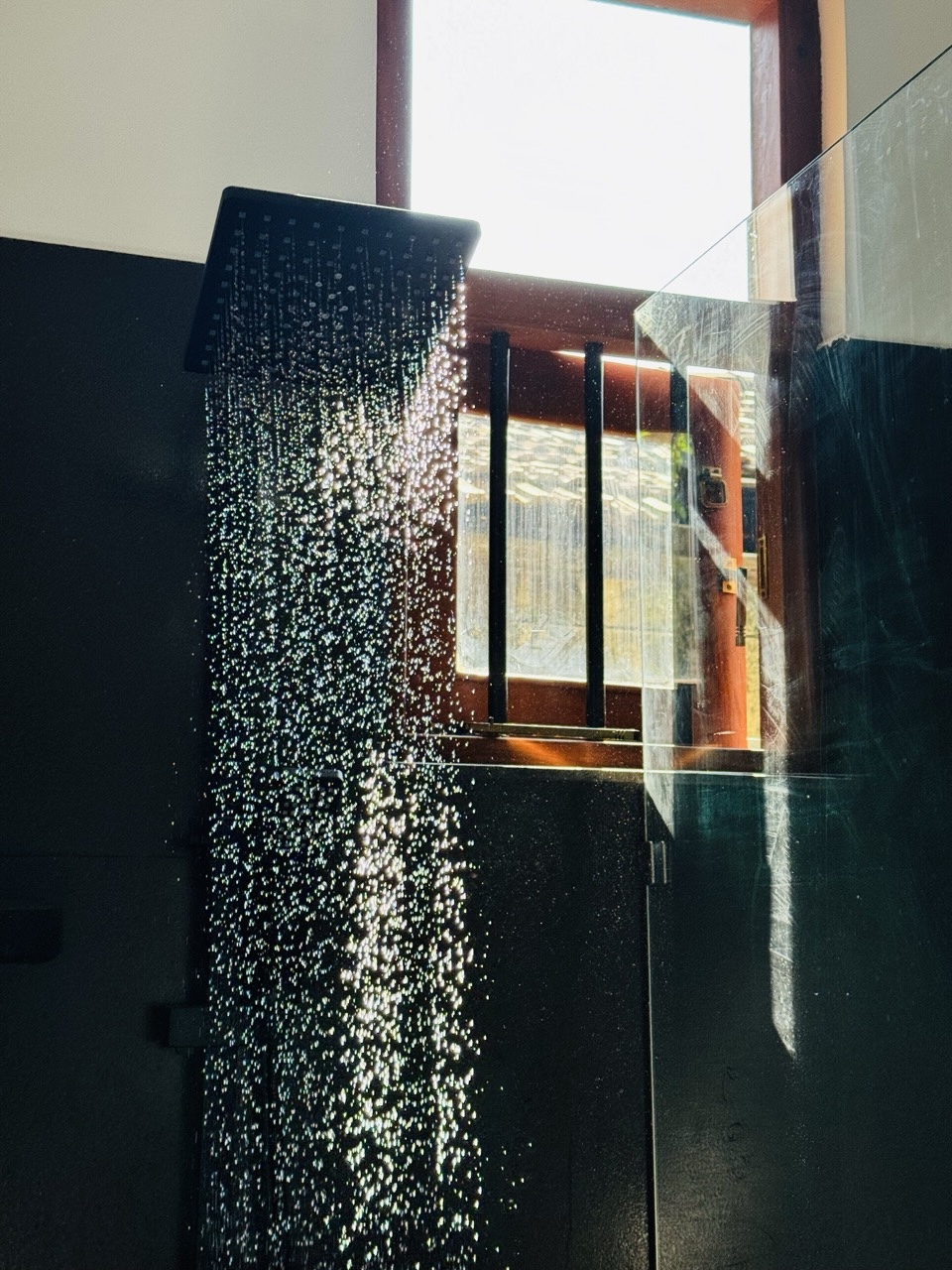 Eco-friendly waterfall-style shower with sustainable fixtures at mettā house